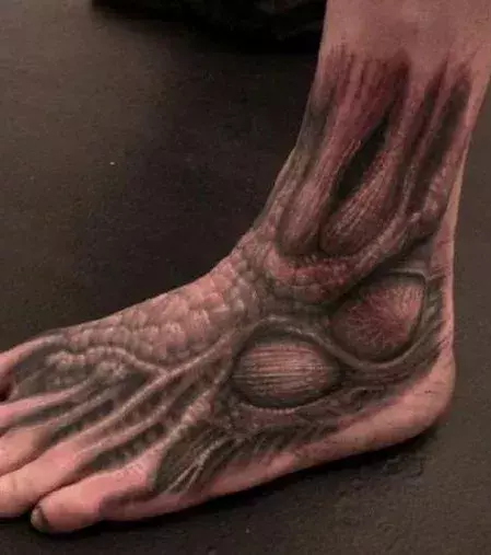 Alien Biomechanic Tattoo auf dem Fuß eines Mannes