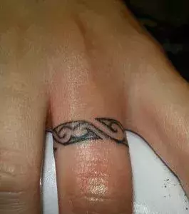 Auf dem Finger eines Mannes: Tribal Ring Tattoo