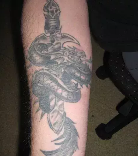 Auf dem Unterarm eines Mannes: ein Drachen Tattoo
