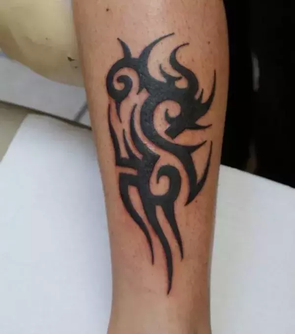 Auf der Wade eines Mannes: ein Tribal Tattoo