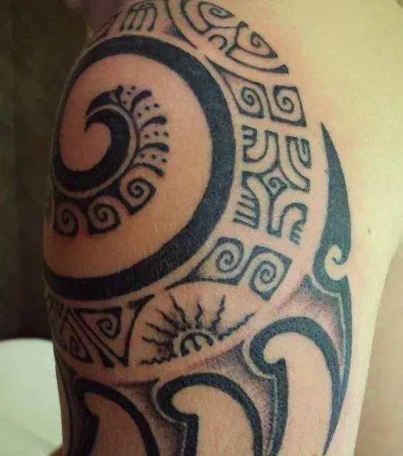 Beeindruckendes Tribal Tattoo auf dem Arm von einem Mann