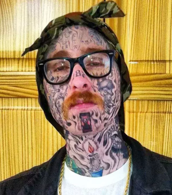 Das Gesicht übersät mit Tattoos