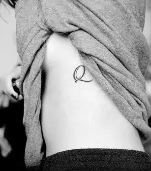 Der Buchstabe Q als Tattoo auf den Rippen