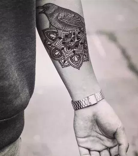 Eine Frau trägt ein Mandala Tattoo auf dem Unterarm.