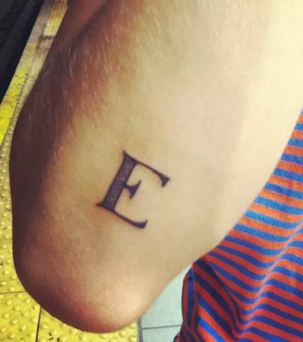 Feines Tattoo des Buchstaben E auf dem Unterarm