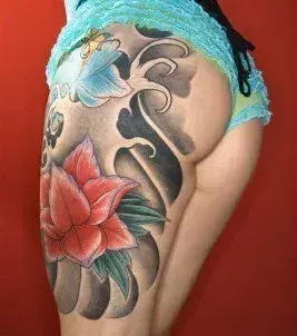Frauen Tattoo: Chinesische Blumen auf dem Oberschenkel