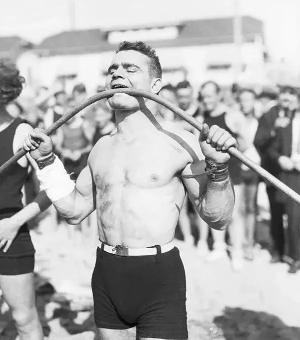 Gus Lasser (1920): Dieser Strongman knickt eine Eisenstange mit dem Mund