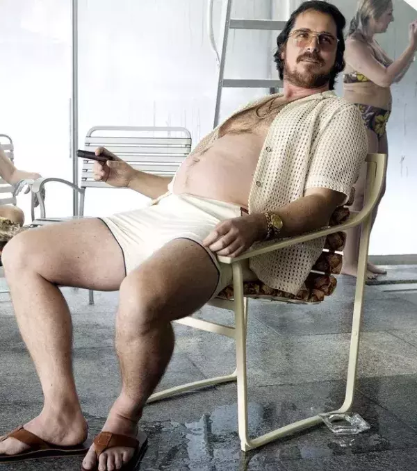 ...hier sitzen er und sein Bauch auf einem Stuhl im Film „American Hustle“!