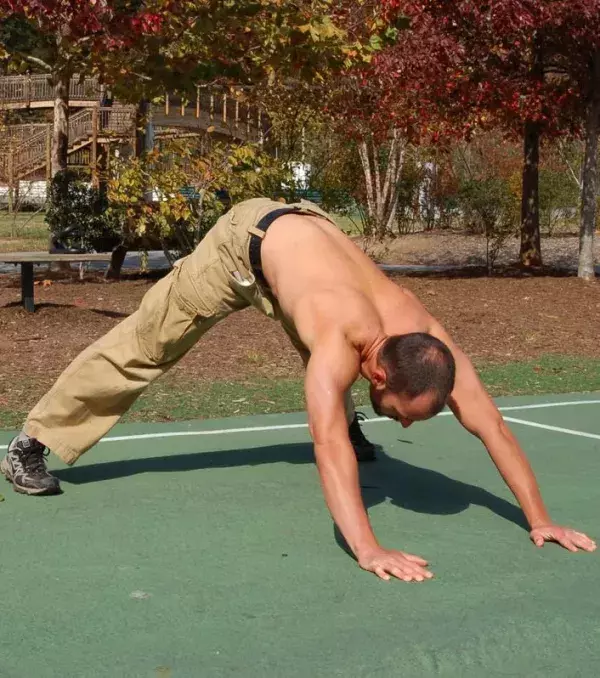 Hindu-Push-Ups. Bei dieser Liegestütz-Variante ist dein Körper in einer Dreiecks-Position und du bringst deinen Oberkörper zwischen den Armen nach unten, und von dort in einer halbrunden Bewegung wieder nach oben.