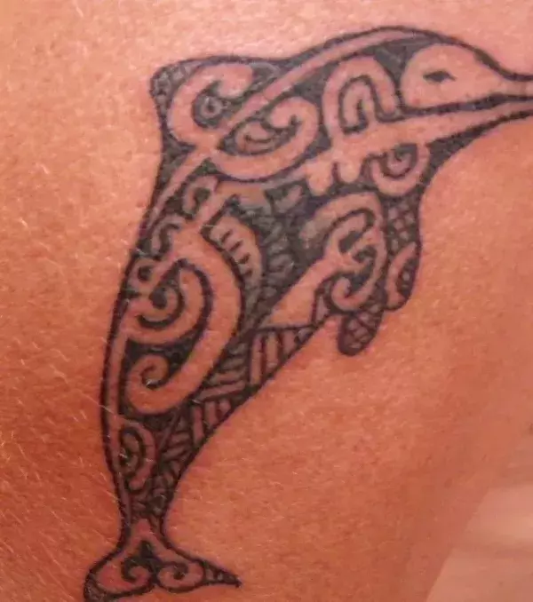 Polynesian / Tahiti Tattoo mit Delfin auf dem Rücken einer Frau
