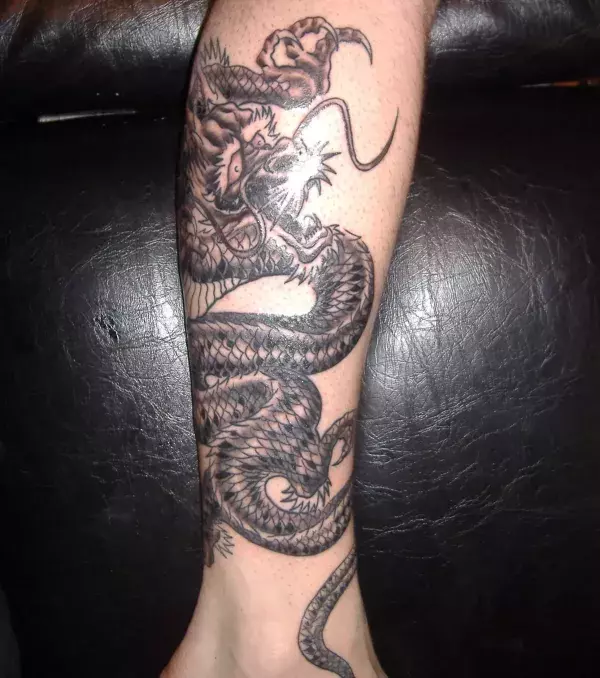 Polynesian Tattoo eines Drachens auf der Wade von einem Mann