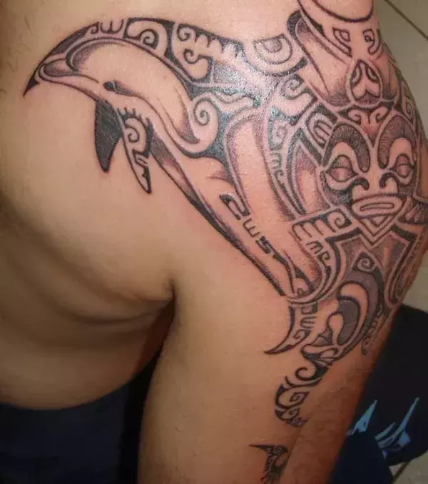 Polynesian Tattoo mit Delfin auf der Schulter eines Mannes