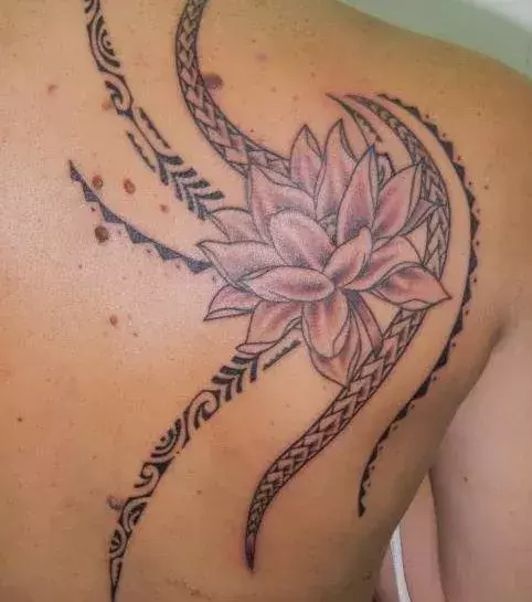 Polynesian Tattoo mit Lotusblume auf dem Schulterblatt einer Frau