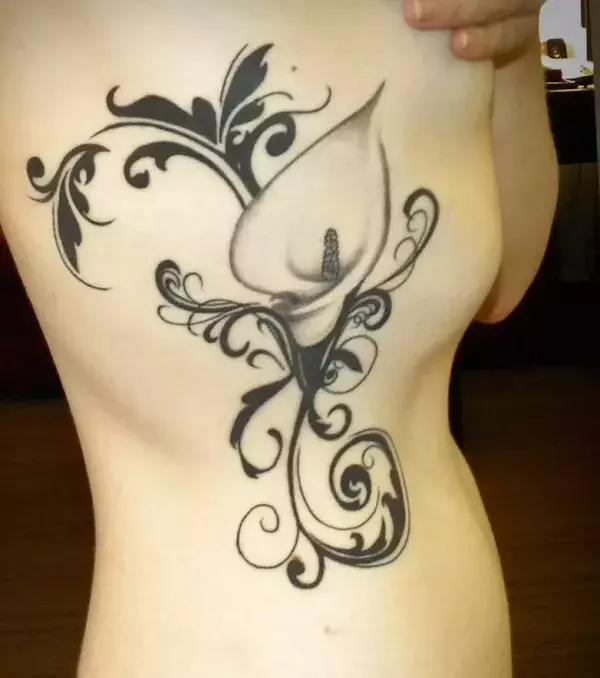 Poynesian Tattoo mit einer Blume auf den Rippen einer Frau