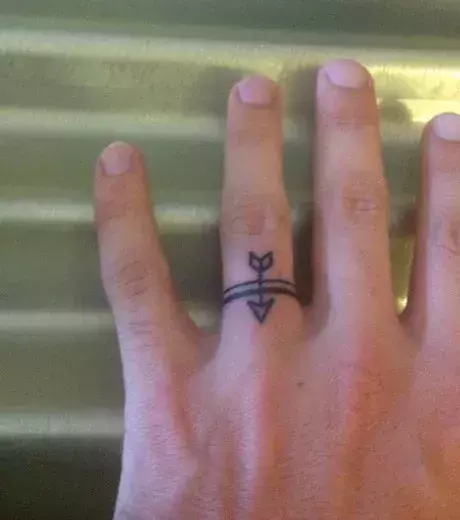 Ring Tattoo mit Pfeil auf dem Finger eines Mannes