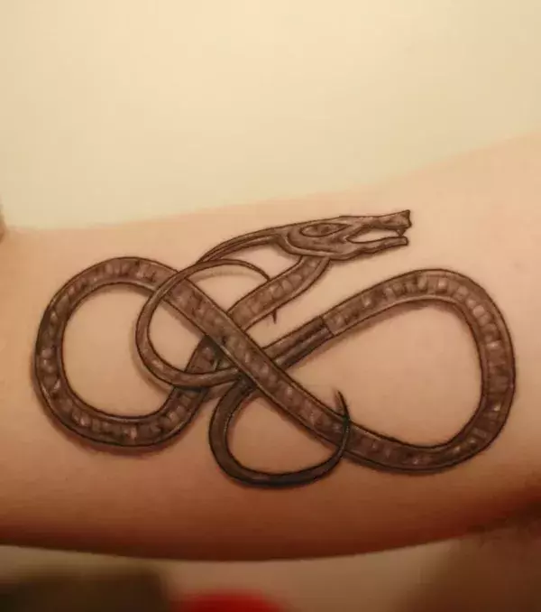 Schlangen Tattoo auf dem Bizeps eines Mannes