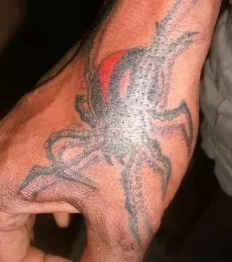 Spinnen Tattoo auf der Hand eines Mannes
