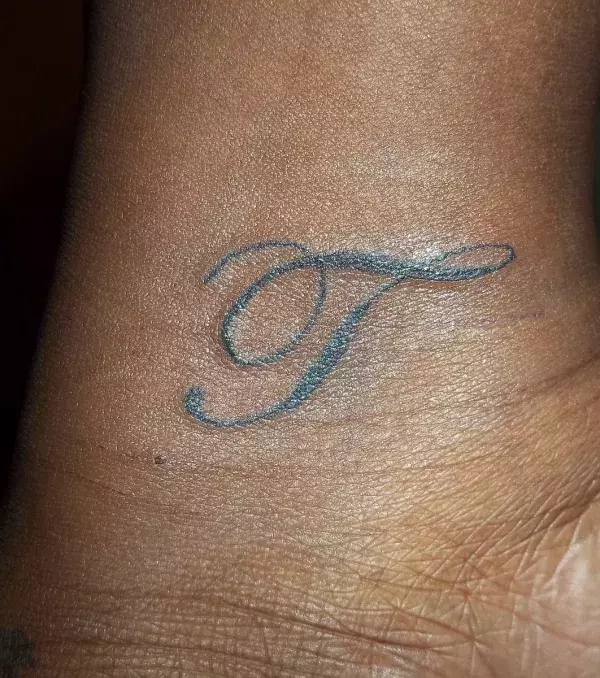 Tattoo Buchstabe T auf dem Handgelenk von einem Mann