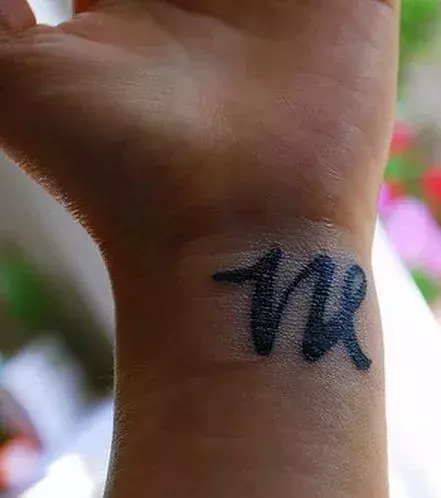 Tattoo des Buchstaben W auf dem Handgelenk
