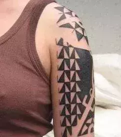 Tattoo einer Frau: Geometrische Formen als Tattoo auf dem Oberarm