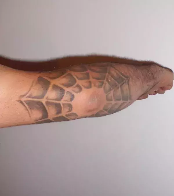Tattoo für einen Mann: Spinnweben Tattoo am Ellbogen