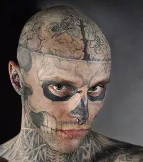 Tattoo im Gesicht und auf dem Schädel eines Mannes