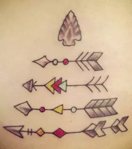 Tattoo mit 4 Pfeilen und roten und gelben Details auf den Rippen