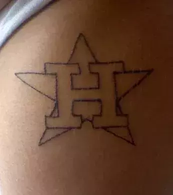 Tattoo mit einem H und einem Stern auf der Hüfte