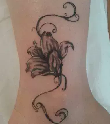 Tattoos für Frauen: Blumen Tattoo auf dem der Wade einer Frau