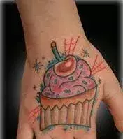 Tattoos für Frauen: Cupcake Tattoo auf der Hand einer Frau