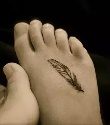 Tattoos für Frauen: Feder Tattoo auf dem Fuß einer Frau