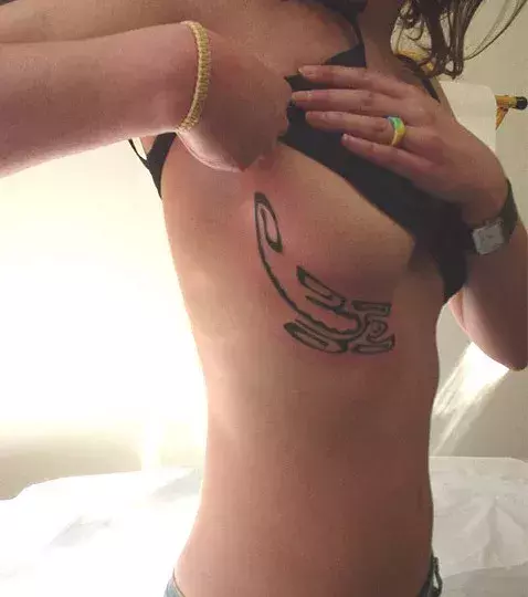 Tattoos für Frauen: Hyroglyphen Tattoo unter der Brust einer Frau