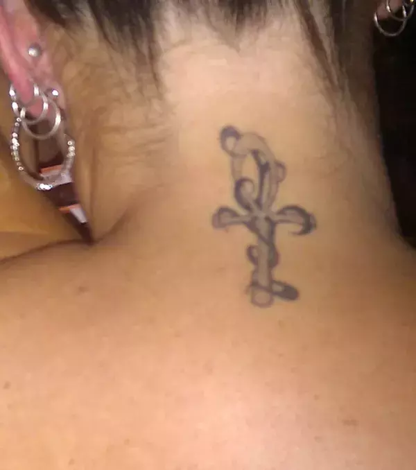 Tattoos für Frauen: Kreuz Tattoo auf dem Nacken einer Frau