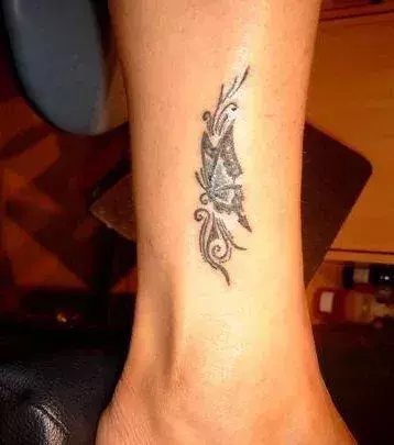 Tattoos für Frauen: Schmetterling Tribal Tattoo auf der Wade einer Frau