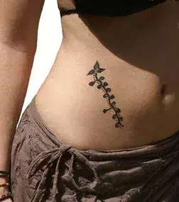 Tattoos für Frauen: Tattoo mit Blumenranke auf dem seitlichen Bauch einer Frau
