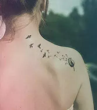 Tattoos für Frauen: Tattoo mit Pusteblume und Vögeln auf der Schulter einer Frau
