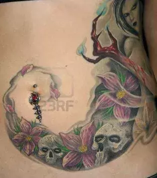 Tattoos für Frauen: Totenkopf und Blumen Tattoo auf dem Bauch einer Frau
