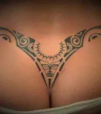 Tattoos für Frauen: Tribal Tattoo auf dem Steißbein einer Frau