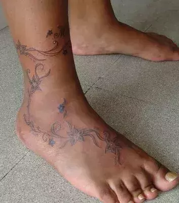 Tribal Blumen Tattoo auf dem Fuß von einem Mann
