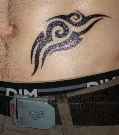 Tribal Tattoo auf dem Bauch eines Mannes
