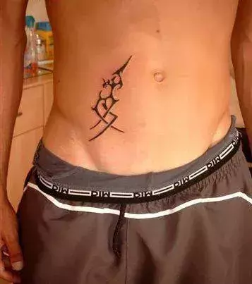 Tribal Tattoo auf dem Bauch von einem Mann