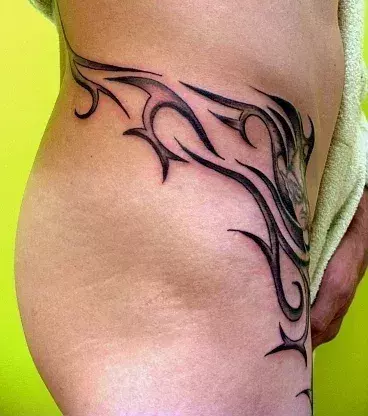 Tribal Tattoo auf der Hüfte eines Mannes