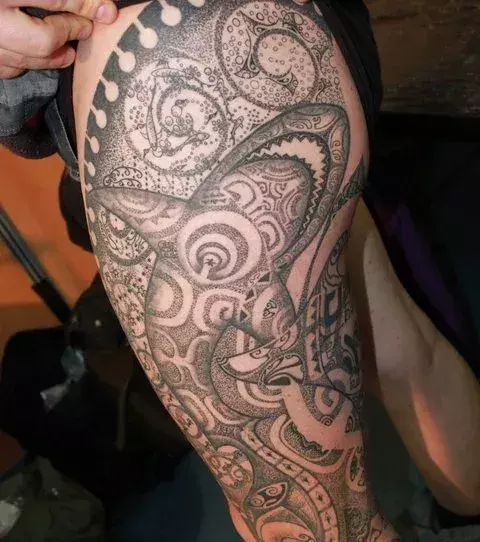 Tribal Tattoo mit Hai auf dem Oberschenkel von einem Mann