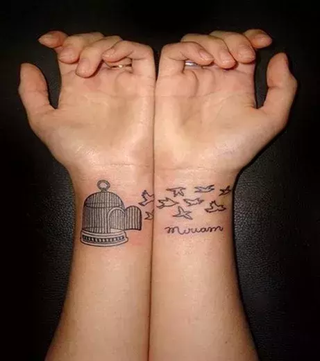 Vogelkäfig Tattoo auf den Armen eines Mannes