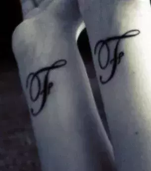Zwei gleiche Tattoos mit dem Buchstabe F auf den Unterarmen